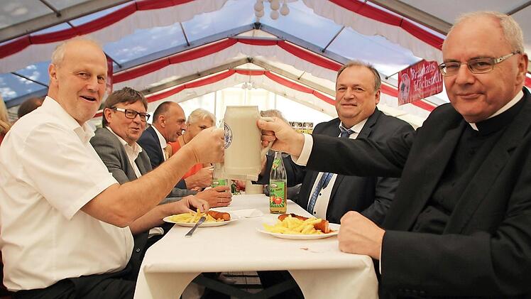 Ein Prosit auf die Gemütlichkeit: Dekan Kilian Kemmer gönnt sich nach der Predigt ein Wasser, für Bürgermeister Gerald Brehm gibt es Bier.