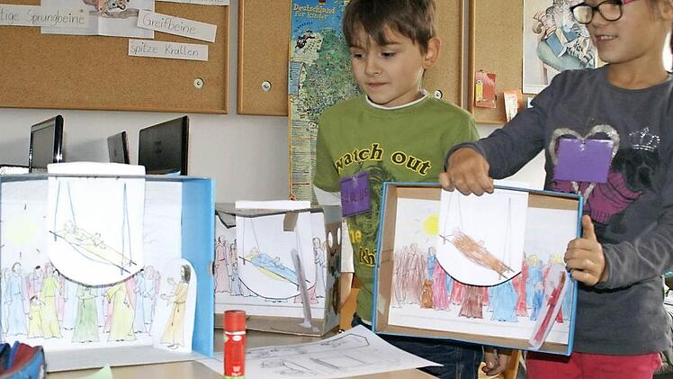 Julius und Antonia sind bereits fertig mit ihren "Wunderboxen" und zeigen bei geöffnetem Deckel, wie das Guckloch-Kino aufgebaut ist.  Foto: Sabine Weinbeer