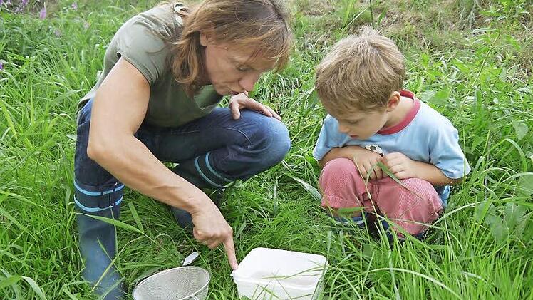 Sabine Martinez und Sohn Pele (5) untersuchen, was sie alles in der Rodach gefangen haben.  Fotos: Berthold Köhler