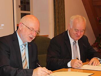 Igensdorfs Bürgermeister Wolfgang Rast (l.) und sein Weißenoher Amtskollege Rudolf Braun setzen ihre Unterschriften unter den Kooperationsvertrag in Sachen Breitbandausbau.  Fotos: fra-press