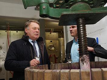 Lorenz Neder (rechts) zeigt Minister Helmut Brunner eine alte Kelter, die für besondere Weine wieder Verwendung findet. Foto: Arkadius Guzy