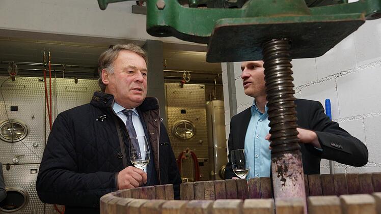 Lorenz Neder (rechts) zeigt Minister Helmut Brunner eine alte Kelter, die für besondere Weine wieder Verwendung findet. Foto: Arkadius Guzy