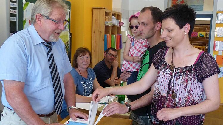 Sie gaben ihre Stimmen für die Europawahl in der Sander Schule ab, von rechts: Daniela und Sven Albert mit Töchterchen Hannah. Die Wahlhelfer Gerhard Zösch, Renate Hartmann und Klaus Johanydes (von links) kümmerten sich um die Wähler, die in ihr Wahllokal gekommen waren. Foto: Klaus Schmitt