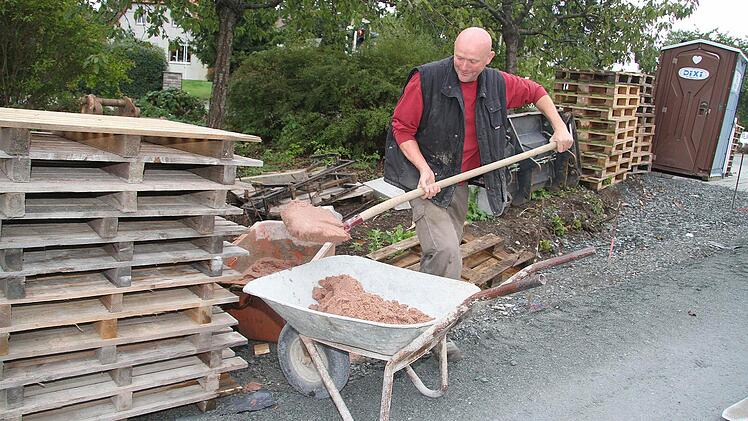 Rudi Gräf macht Mörtel an. Denn nicht nur neue Parkplätze entstehen, sondern auch die Oberflächenentwässerung wurde im Zuge der Baumaßnahmen optimiert.