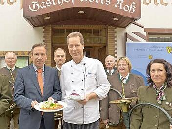 Landrat Alexander Tritthart, Gastronome wie Gerhard Sörgel vom Gasthof "Rotes Roß" in Heroldsberg und das Parforceensemble der Jägervereinigung Erlangen blasen zum Auftakt der Wildbretwochen im Landkreis Erlangen-Höchstadt.  Foto: Bernd Böhner