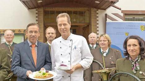 Landrat Alexander Tritthart, Gastronome wie Gerhard Sörgel vom Gasthof "Rotes Roß" in Heroldsberg und das Parforceensemble der Jägervereinigung Erlangen blasen zum Auftakt der Wildbretwochen im Landkreis Erlangen-Höchstadt.  Foto: Bernd Böhner