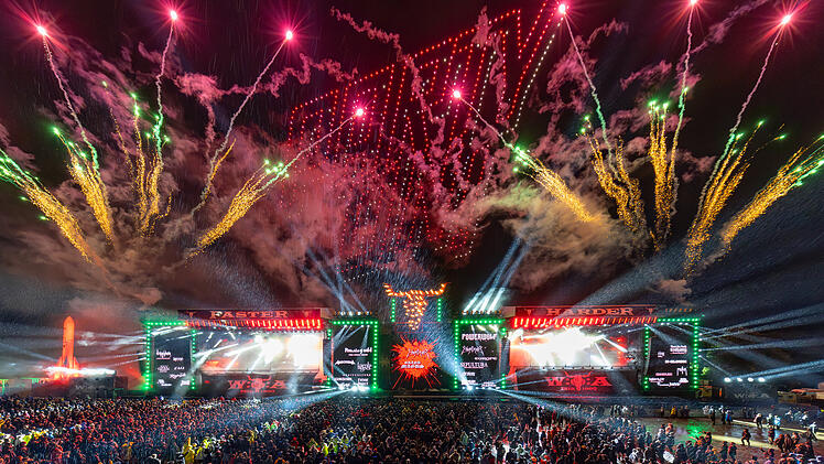 Mit "Party On"-Schriftzug am Himmel und einigen Band des 2026-er Line-ups auf den Leinw&auml;nden: Mit diesem Feuerwerks-Foto k&uuml;ndigen die Veranstalter das Wacken Open Air 2026 an. - WOA Festival GmbH  Wacken Open Air 2026 Wacken Bierpreis Bierpreise Preissenkung g&uuml;nstiger Bier 35 Jubil&auml;um Holy Ground Metal Festival Heavy Metal Festivalgel&auml;nde Bierbecher Bechergr&ouml;&szlig;e 0,5 Liter 6,90 Euro 13,80 Euro Literpreis Thomas Jensen Holger H&uuml;bner Metal-Fans Metalheads Headliner Line-up Judas Priest Def Leppard Powerwolf Schleswig-Holstein Festival Sommer 2026 Infrastruktur Schlamm Wege Platten