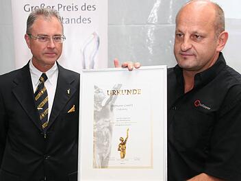 Firmenchef Roland Hofmann präsentiert seine Preisurkunde. Links Robert Knitt von der Oskar-Patzelt-Stiftung.  Foto: fra