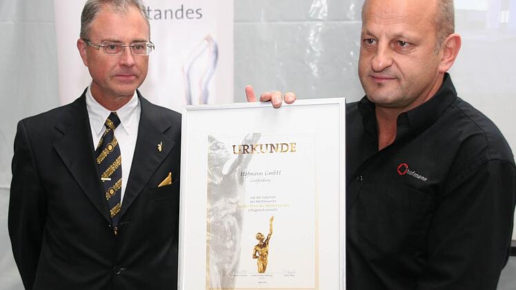 Firmenchef Roland Hofmann präsentiert seine Preisurkunde. Links Robert Knitt von der Oskar-Patzelt-Stiftung.  Foto: fra