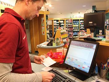 Prüfender Blick: Bernward Unger sieht im Computer nach, ob das gewünschte Medikament auf Lager ist. Foto: Ralf Dieter