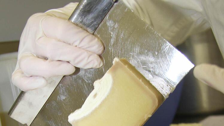 Von den Seifenblöcken schneidet Regine Bär jedes Seifenstück einzeln ab - in diesem Fall von einer Vanilleseife.