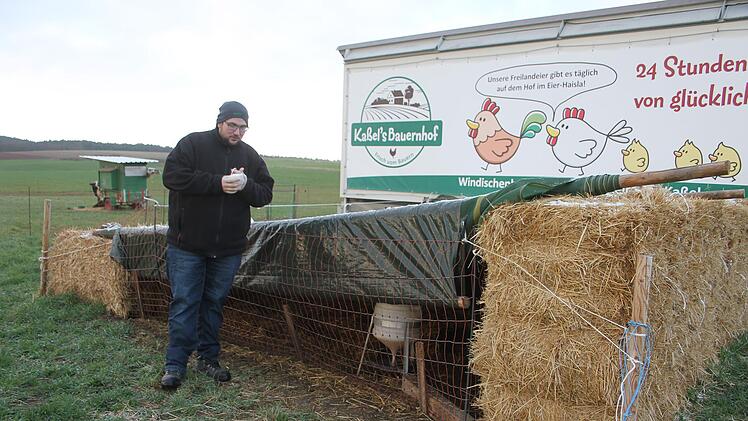 Daniel Kaßel hält seine Hühner in einem mobilen Stall. Mit Strohballen und Abdeckungen hat er einen kleinen Freilauf gebaut, um seine Tiere vor der Vogelgrippe zu schützen.