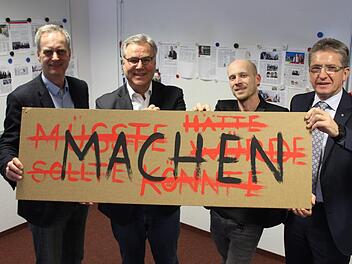 IZK-Geschäftsführer Hendrik Montag-Schwappacher, CIK-Geschäftsführer Thomas Kneitz, Christian Zagel von der Hochschule Coburg und IZK-Vorstandssprecher Hans Rebhan (von links) halten ein Schild hoch, das das IZK repräsentiert. Die Verantwortlichen sehen sich als Macher. Foto: Andreas Schmitt