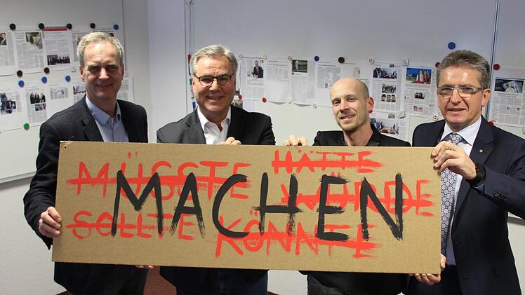 IZK-Geschäftsführer Hendrik Montag-Schwappacher, CIK-Geschäftsführer Thomas Kneitz, Christian Zagel von der Hochschule Coburg und IZK-Vorstandssprecher Hans Rebhan (von links) halten ein Schild hoch, das das IZK repräsentiert. Die Verantwortlichen sehen sich als Macher. Foto: Andreas Schmitt
