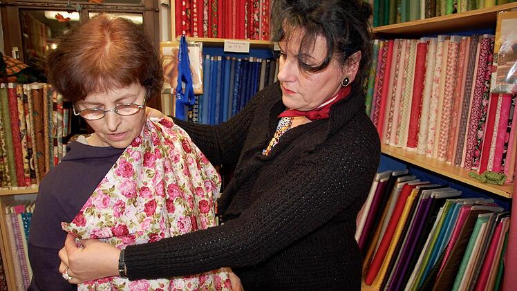 Maria Rau (rechts) und ihrer Mitarbeiterin Erzs&egrave;bet Moln&agrave;r vor einem vollen Stoffregal. Foto: Roland Betz