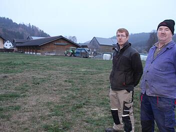 Johannes  (links) und Christian Nickel stehen dort, wo sie einen neuen Stall für ihre Milchkühe bauen wollen. Im Hintergrund: der bestehende Stall, in dem künftig ausschließlich die jungen Kälber aufgezogen werden sollen. Foto: Veronika Schadeck