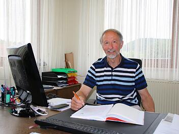Auch wenn der Euerdorfer Bürgermeister Peter Bergel (69) oft mit Handy und Computer arbeitet: Alle wichtigen Infos stehen trotzdem in seinem großen Buch. Foto: Ralf Ruppert