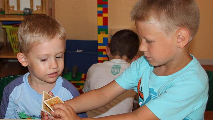 Daniel (rechts) übersetzt dem dreijährigen Roman das Spiel.