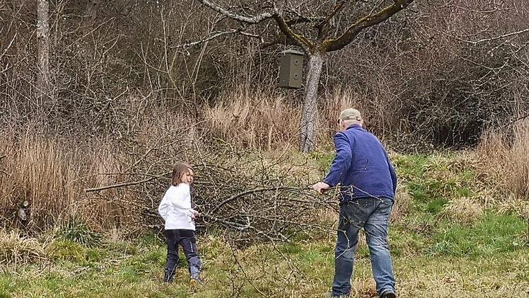 Jung und Alt helfen zusammen beim Aufräumen des Baumschnittes auf der BN-Streuobstwiese Foto: Christine Ebert-Booms