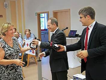 Dank an die vielen Helfer, die tagtäglich das Rote-Kreuz mit Leben erfüllen: Dr. Alexander Siebel (Mitte) und Kreis-Geschäftsführer Thomas Stadler (rechts) überreichen den Helfern ein Präsent. Fotos: Klaus Werner
