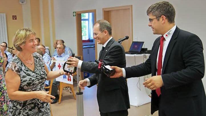 Dank an die vielen Helfer, die tagtäglich das Rote-Kreuz mit Leben erfüllen: Dr. Alexander Siebel (Mitte) und Kreis-Geschäftsführer Thomas Stadler (rechts) überreichen den Helfern ein Präsent. Fotos: Klaus Werner