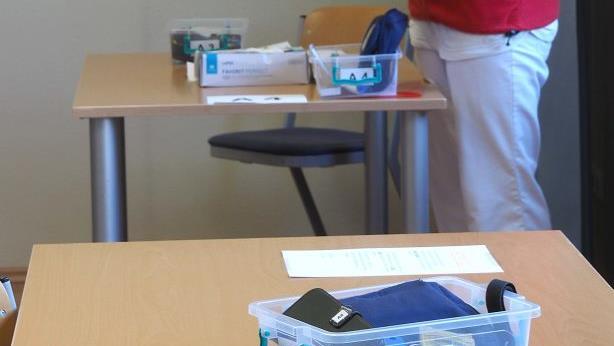 Die Mitarbeiterinnen der ambulanten Pflege holen die n&ouml;tigen Utensilien und Unterlagen f&uuml;r ihre Pflegetouren und -patienten nur ab. In verschiedenen K&ouml;rbchen ist alles N&ouml;tige schon bereit gestellt, so dass die Mitarbeiterinnen m&ouml;glichst wenig k&ouml;rperliche N&auml;he zueinander haben.  Foto: Christoph Winter