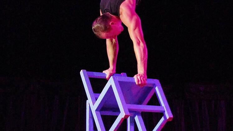 Auf den Sektflaschen stapelt Roberto Frank insgesamt sieben Stühle.