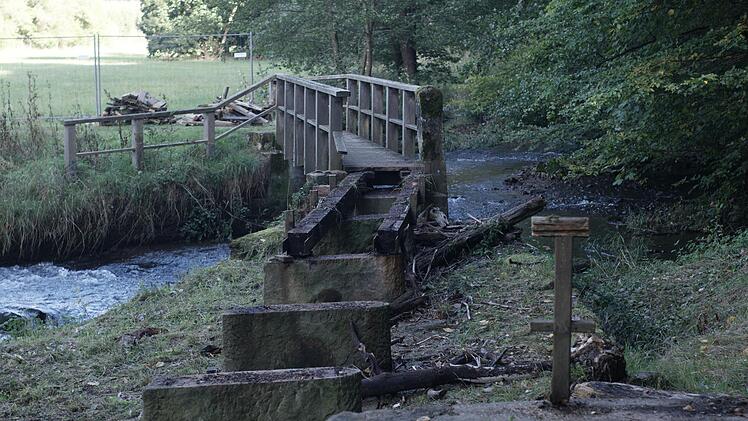 Die Hälfte des hölzernen Überbaus des Fußgängerstegs im Staatsbad wurde abgebaut. Bis November soll die Sinn-Brücke fertig sein und wieder freigegeben werden. Foto: Steffen Standke