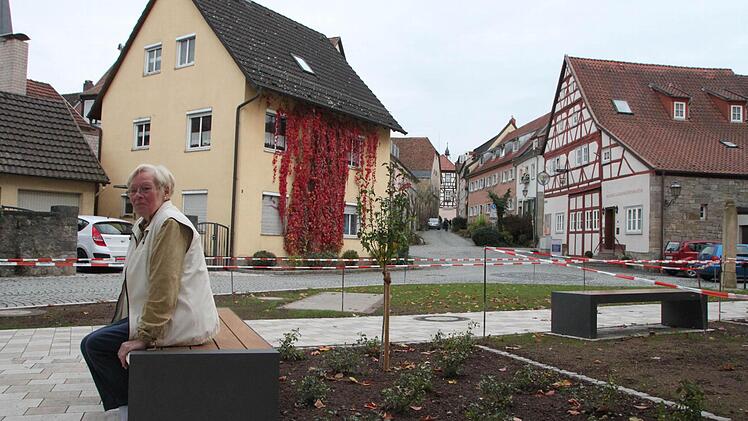 Edeltrud Müller sitzt das erste Mal auf einer der neuen Bänke. Ein bisschen hat auch sie sich gewundert, dass keine eine Lehne hat. Foto: H. Beudert