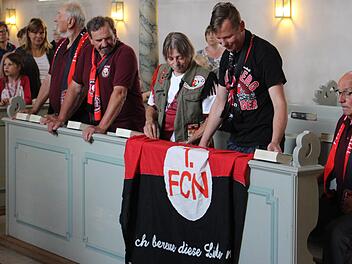 "Ich bereue diese Liebe nicht", ist auf der FCN-Fahne zu lesen. Sie wurde am Sonntag in der Kirche Sankt Oswald ausgebreitet. Foto: Evi Seeger