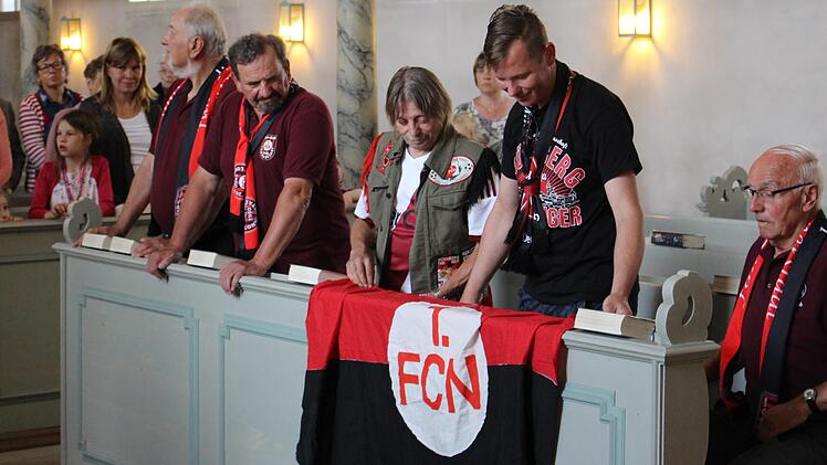 "Ich bereue diese Liebe nicht", ist auf der FCN-Fahne zu lesen. Sie wurde am Sonntag in der Kirche Sankt Oswald ausgebreitet. Foto: Evi Seeger