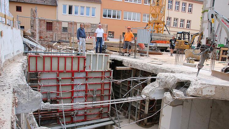 Stadtbaumeister Detlef Mohr (von links), Architekt Andreas Reuter und Polier Markus Haas begutachten Treppenhaus, Aufzugschacht und letzte Abbrucharbeiten im Keller des ehemaligen Kaufhauses.