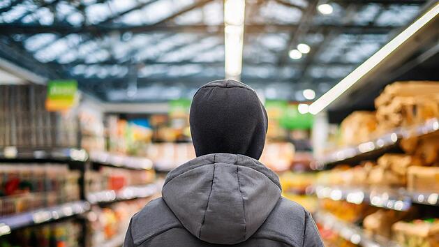 Ein Mann stiehlt etwas in einem Supermarkt, Diebstahl, Raub