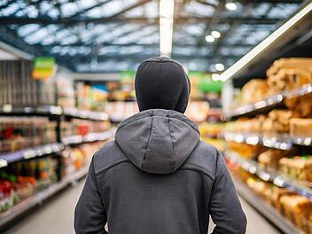 Ein Mann stiehlt etwas in einem Supermarkt, Diebstahl, Raub