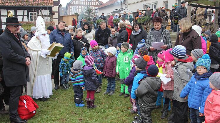 Vom Nikolaus und "Knecht Ruprecht" in Person von Bürgermeister Helmut Dietz (links neben dem Nikolaus), wurden die Kinder des Kindergartens Memmelsdorf, nachdem sie einiges zum Besten gegeben hatten. Foto: Helmut Will