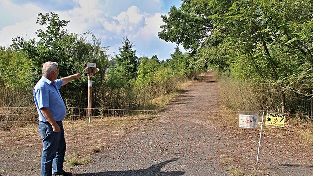 Stopp f&uuml;r Wanderer. B&uuml;rgermeister Werner Riegel zeigt auf den Weg, der mit einem Elektrozaun widerrechtlich abgesperrt wurde und somit die Wanderstrecke zwischen Eichelberg und Ebern unterbricht.  Foto: Helmut Will