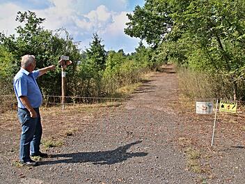 Stopp für Wanderer. Bürgermeister Werner Riegel zeigt auf den Weg, der mit einem Elektrozaun widerrechtlich abgesperrt wurde und somit die Wanderstrecke zwischen Eichelberg und Ebern unterbricht.  Foto: Helmut Will