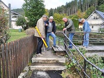 Das Bild zeigt (von links) VdK-Lotse Günter Bauer, Vorsitzenden  Wolfgang Förtsch, seinen Stellvertreter Roland Freund und  Frauenbeauftragte Anneliese Munzer am sogenannten "Stadelmanns-Wehr".- An den beiden Aufgängen zum Steg sollte geprüft werden, ob beiderseits eine Rampe angelegt werden kann. Die Handläufe müssen gut fassbar und stabil sein.     Tristan Förtsch