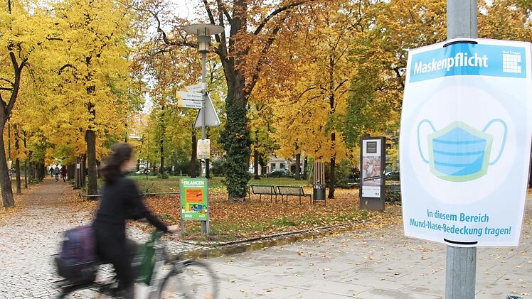 In der Innenstadt von Erlangen, hier am Bohlenplatz, weisen Schilder auf die Maskenpflicht hin.  Foto: C. Bauriedel