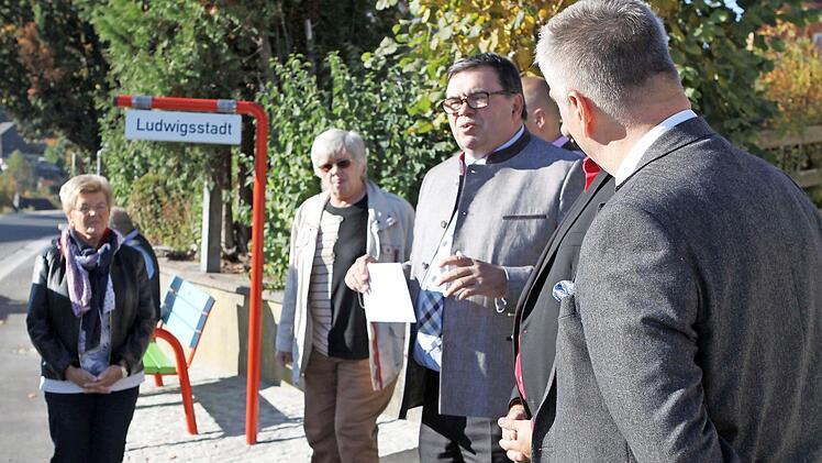 Die Nutzer der Mitfahrbänke können Schilder ausklappen, auf denen steht, wo sie hinwollen. Tschirns Bürgermeister Peter Klinger (mit Zettel) lud seine Kollegen zum Ausprobieren ein. Fotos: Michael Wunder
