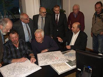 Vergleichen die Neufassung des Katasters mit früheren Planwerken: Die Feldgeschworenen Ludwig Hilpert (von links, sitzend) Fridolin Schubert und Manfred Greubel sowie (stehend, von links) Bernhard Simon vom Vermessungsamt, Altbürgermeister Siegfried Erhard, Bürgermeister Franz Kuhn, Konrad Unsleber (Leiter des Vermessungsamts Bad Kissingen) sowie die Feldgeschworenen Alfred Schubert und Günther Kuhn.  Foto: S. Geiger