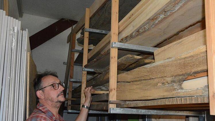 Harald Fischlein prüft seinen Werkstoff: Das Holz einer abgebauten Scheune. Foto: Elisabeth Assmann