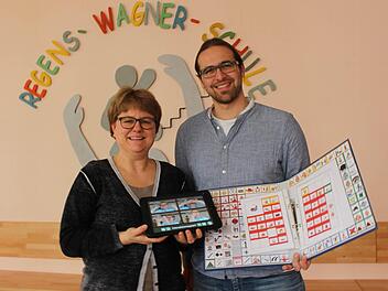 iPad gegen Ordner: Susanne Rech und Tobias Fürst zeigen verschiedene Methoden, wie man nicht-sprechende Kinder unterstützen kann.  Foto: Lisa Kieslinger