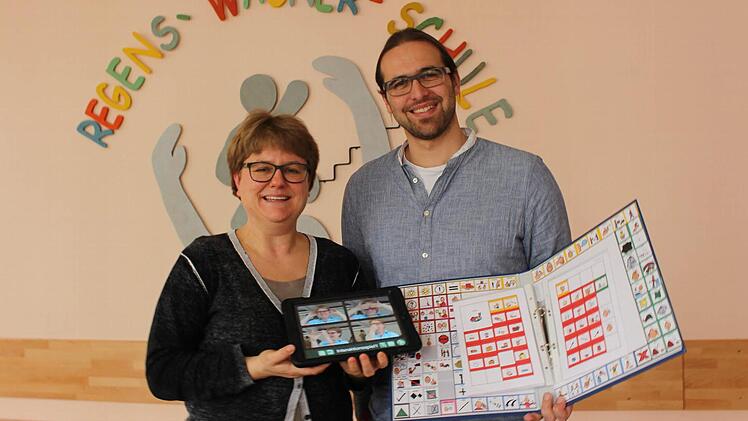 iPad gegen Ordner: Susanne Rech und Tobias Fürst zeigen verschiedene Methoden, wie man nicht-sprechende Kinder unterstützen kann.  Foto: Lisa Kieslinger