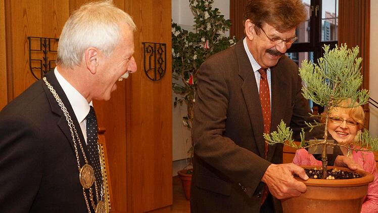 Bürgermeister Ernst Stross (links) darf im Herbst als Geschenk der Stadträte eine Zerreiche im Familienwald pflanzen. Reimar Glückler stellt ihm daher symbolisch ein Topfbäumchen auf den Tisch. Fotos: Arkadius Guzy