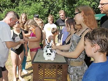 Vorsitzender Steffen Stumpf (links) informierte die Kinder und Jugendlichen über die Kleintierzucht und zeigte anschaulich, wie junges Geflügel beringt wird und Hasen tätowiert werden.  Foto: Michael Stelzner