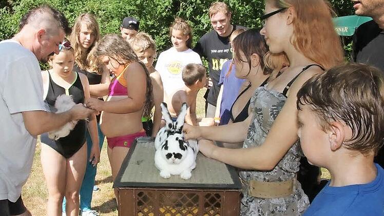 Vorsitzender Steffen Stumpf (links) informierte die Kinder und Jugendlichen über die Kleintierzucht und zeigte anschaulich, wie junges Geflügel beringt wird und Hasen tätowiert werden.  Foto: Michael Stelzner