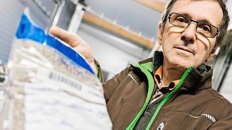 Herbert Hanna zeigt das stärkehaltige Futter, das seine Hühner erhalten. Es soll möglichst wenig stauben, um so Dreck zu vermeiden.