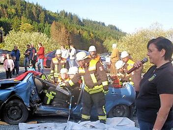 Kommandantin Kerstin May erklärt jeden Arbeitsschritt bei der Bergung eines "Verletzten" aus einem Unfallfahrzeug. Foto: Susanne Deuerling