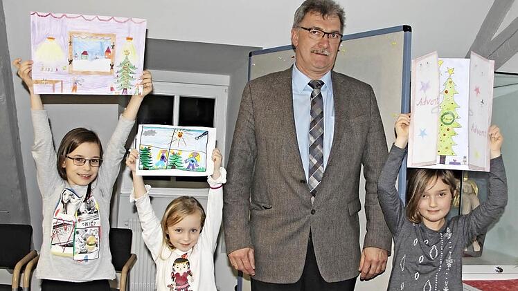 Jeweils zum Weihnachtsmarkt ruft die Gemeinde zu einem Malwettbewerb für Kinder bis zu zwölf Jahren auf. Diesmal lautete das Thema: "Schau hinein, schau hinaus - unser Fenster im Advent." Eine Jury hat unter 76 Einsendungen drei Preisträger ermittelt: die neunjährige Selina Schneider (von links) aus Memmelsdorf, die fünfjährige Jana Lieb und die achtjährige Sina Knauf, beide Untermerzbach. Stolz hoben die Mädchen ihre Werke in die Höhe. Bürgermeister Helmut Dietz (Zweiter von rechts) überrei...